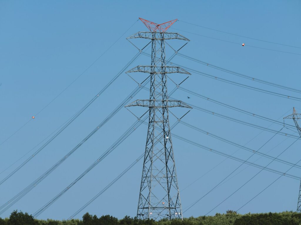 Tall electrical tower with power lines against sky